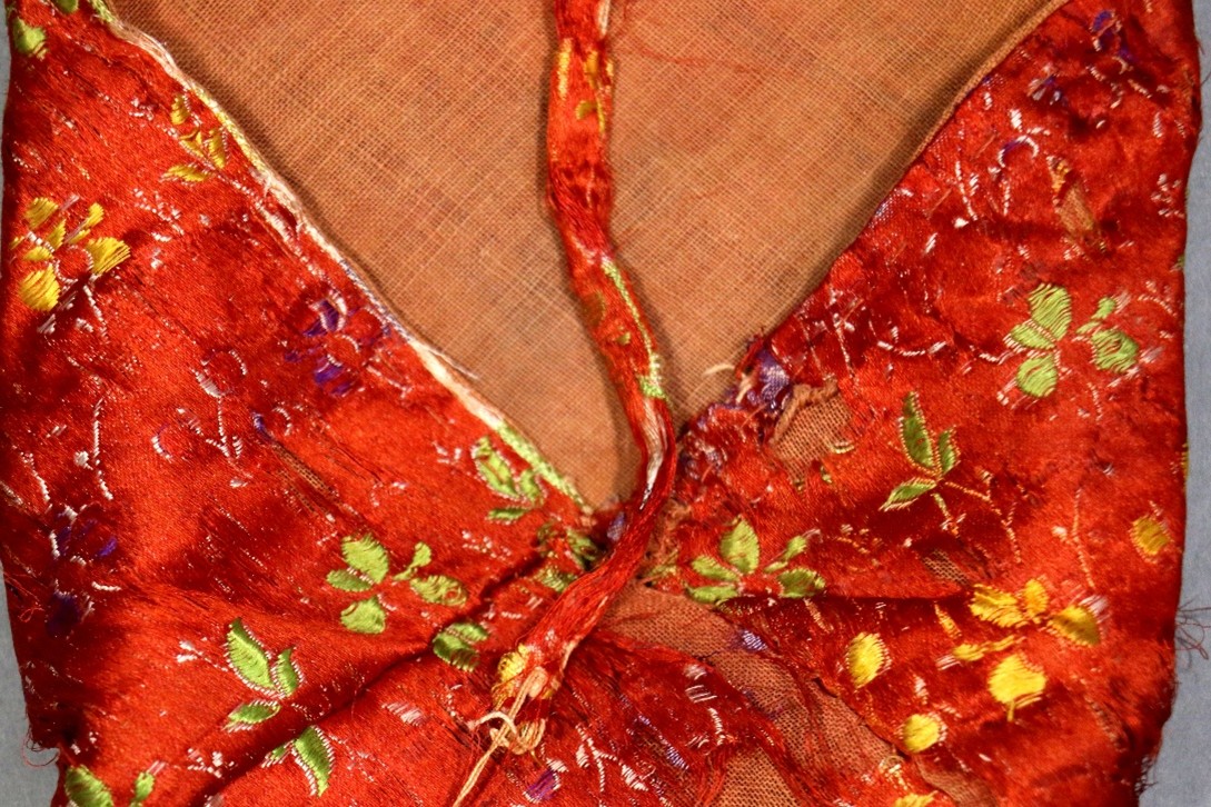 Detail of a silk manuscript bag from the QNL collection showing abrasion and tearing resulting from continued use as an enclosure